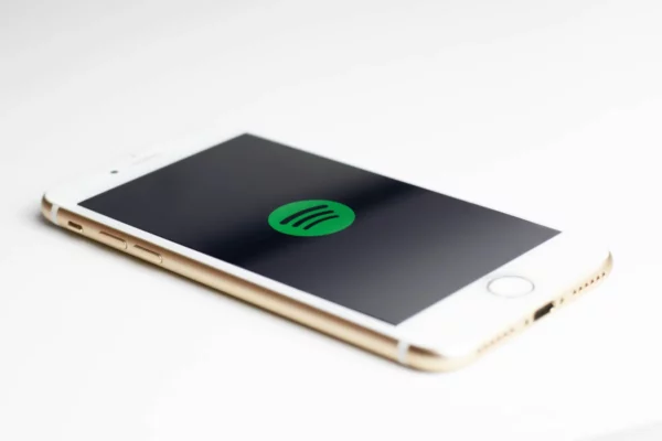 iPhone on white surface with Spotify logo displayed on screen